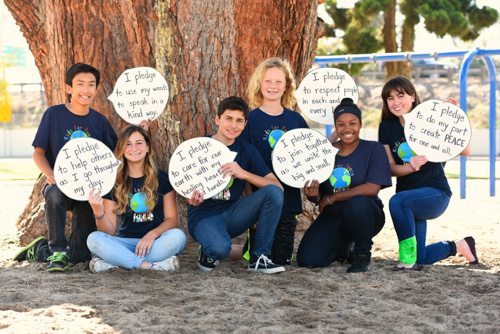 Kids holding signs of Kids For Peace pledge